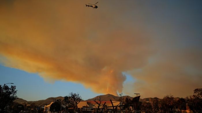  A police helicopter flying over burned areas following the Palisades Fire at the Pacific Palisades neighborhood in Los Angeles. (Image: Reuters)